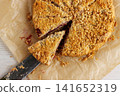 Overhead view of homemade cherry crumb cake with streusel topping on baking paper, with a slice lifted on a knife Overhead view of homemade cherry crumb cake with streusel topping on baking paper, with a slice lifted on a knife 141652319