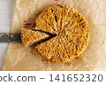 Overhead view of homemade cherry crumb cake with streusel topping on baking paper, with a slice lifted on a knife Overhead view of homemade cherry crumb cake with streusel topping on baking paper, with a slice lifted on a knife 141652320