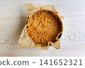 Overhead view of a whole homemade cherry crumb cake with golden streusel topping in a parchment lined metal springform pan on a wooden table Overhead view of a whole homemade cherry crumb cake with golden streusel topping in a parchment lined metal springform pan on a wooden table 141652321