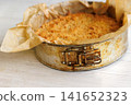 Whole homemade cherry crumb cake with golden streusel topping in a parchment-lined metal springform pan. Selective focus Whole homemade cherry crumb cake with golden streusel topping in a parchment-lined metal springform pan. Selective focus 141652323
