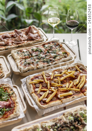many different Pinsa types on garden restaurant pizza slice buffet table outdoors many different Pinsa types on garden restaurant pizza slice buffet table outdoors 141652458