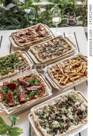 many different Pinsa types on garden restaurant pizza slice buffet table outdoors 141652460