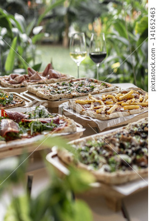 many different Pinsa types on garden restaurant pizza slice buffet table outdoors many different Pinsa types on garden restaurant pizza slice buffet table outdoors 141652463
