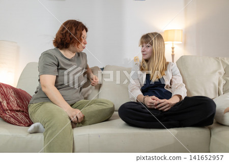 Mother and daughter having a serious conversation at home Mother and daughter having a serious conversation at home 141652957