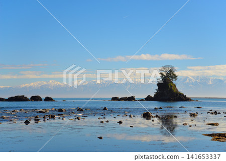 Onna-iwa Rock and the Tateyama mountain range as seen from Amaharashi Coast (Takaoka City, Toyama Prefecture) Onna-iwa Rock and the Tateyama mountain range as seen from Amaharashi Coast (Takaoka City, Toyama Prefecture) 141653337