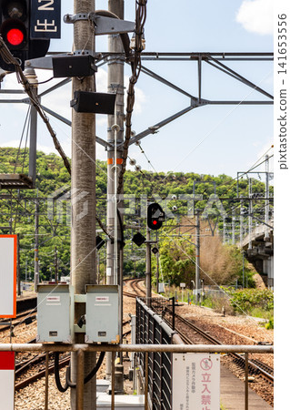 鐵路線、鐵路設備和信號燈,背景是藍天和鬱鬱蔥蔥的青山。 鐵路線、鐵路設備和信號燈,背景是藍天和鬱鬱蔥蔥的青山。 141653556