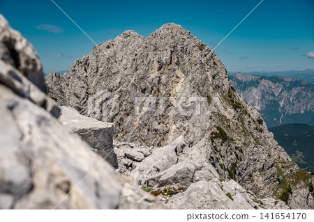 View from the middle Ponza mountain in Triglav National Park, Slovenia, towards the high Ponza peak with white rocky alpine valley routes, steep Julian Alps ridges and dramatic high mountain landscape View from the middle Ponza mountain in Triglav National Park, Slovenia, towards the high Ponza peak with white rocky alpine valley routes, steep Julian Alps ridges and dramatic high mountain landscape 141654170