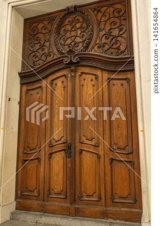 Ornate Wooden Portal Door with Carved Transom Panel at Historic Building Entrance in Vienna Austria 141654864