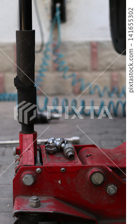 A red car hydraulic lift. A red car hydraulic lift. 141655302
