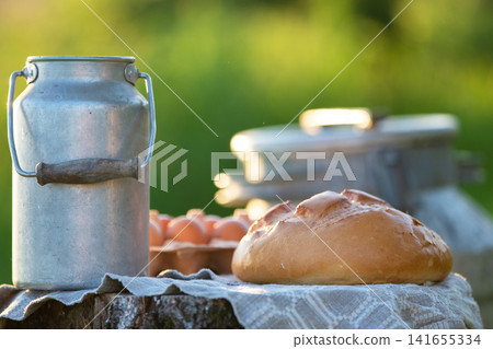 Farmhouse breakfast setting with fresh produce and rustic utensils in natural light during early morning hours Farmhouse breakfast setting with fresh produce and rustic utensils in natural light during early morning hours 141655334
