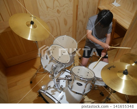 A child playing the drums (photographed from above) 141655348
