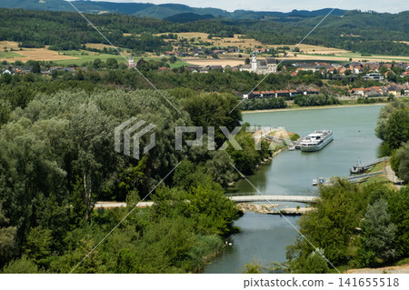 Scenic landscape of the Danube river with a cruise ship and green hills in Melk, Austria Scenic landscape of the Danube river with a cruise ship and green hills in Melk, Austria 141655518