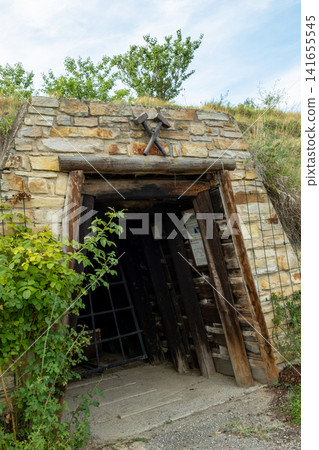 Entrance to an old mine shaft built with stone wall and wooden beams Entrance to an old mine shaft built with stone wall and wooden beams 141655545