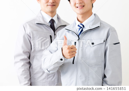 A young man and a middle-aged man in work clothes giving a thumbs-up A young man and a middle-aged man in work clothes giving a thumbs-up 141655851
