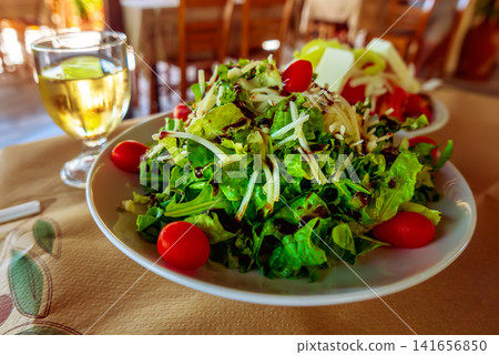 Greek salad with white wine in a traditional restaurant Greek salad with white wine in a traditional restaurant 141656850