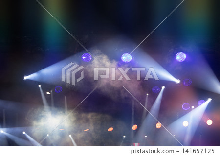 Colorful stage lights illuminating a vibrant performance at a music festival in the evening Colorful stage lights illuminating a vibrant performance at a music festival in the evening 141657125