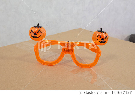 Bright orange glasses with pumpkin decorations for Halloween celebration on a plain background Bright orange glasses with pumpkin decorations for Halloween celebration on a plain background 141657157