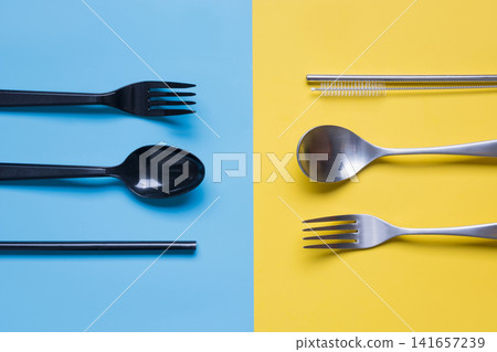 Comparison of reusable metal cutlery, and eco wooden spoon, knife. View from above. Top view. Flat lay. Comparison of reusable metal cutlery, and eco wooden spoon, knife. View from above. Top view. Flat lay. 141657239