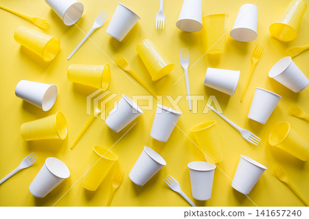 Disposable picnic utensils on yellow. Environment eco friendly discarded plastic garbage for recycle concept.Top view. Flat lay. Disposable picnic utensils on yellow. Environment eco friendly discarded plastic garbage for recycle concept.Top view. Flat lay. 141657240