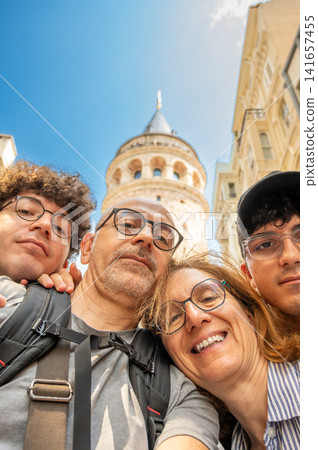 Istanbul, turkey, august 2, 2025. Happy family of four taking a selfie while exploring the historic galata tower and city architecture in istanbul, turkey Istanbul, turkey, august 2, 2025. Happy family of four taking a selfie while exploring the historic galata tower and city architecture in istanbul, turkey 141657455