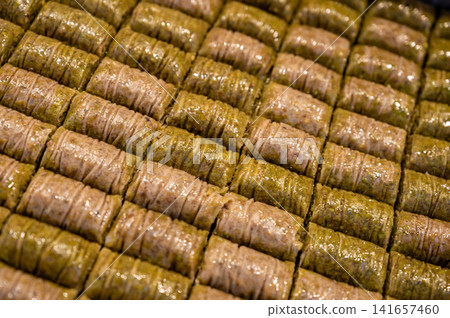 Istanbul, turkey, august 2, 2025. Rows of traditional turkish baklava rolls featuring a blend of pistachio and rich syrup, forming a delicious middle eastern dessert Istanbul, turkey, august 2, 2025. Rows of traditional turkish baklava rolls featuring a blend of pistachio and rich syrup, forming a delicious middle eastern dessert 141657460