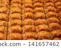 Istanbul, turkey, august 2, 2025. Sweet baklava pieces in a tray, drenched in syrup, ready for serving or sale. Classic turkish pastry 141657462