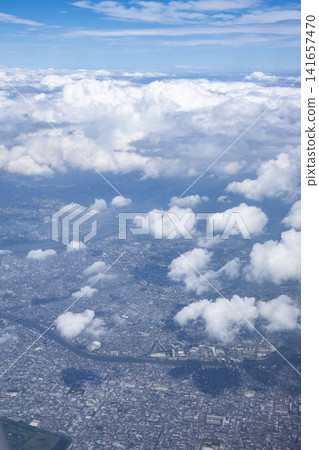 A panoramic aerial view of a winding river and a metropolis seen through a gap in the clouds. A panoramic aerial view of a winding river and a metropolis seen through a gap in the clouds. 141657470