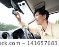 A young man checks the dashcam footage in his car. 141657683
