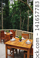 Wooden tables set up in an outdoor cafe against the background of a tropical jungle 141657783