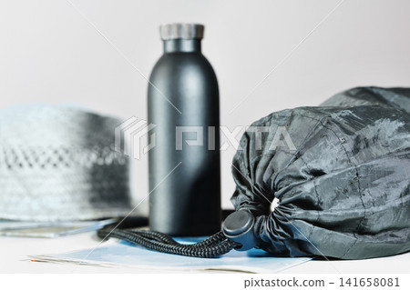 Black rucksack , bottle and maps Black rucksack , bottle and maps 141658081
