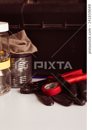 Tools and equipment such as work gloves, insulating tape and pliers, ready for various tasks, symbolize work and craftsmanship. Tools and equipment such as work gloves, insulating tape and pliers, ready for various tasks, symbolize work and craftsmanship. 141659049