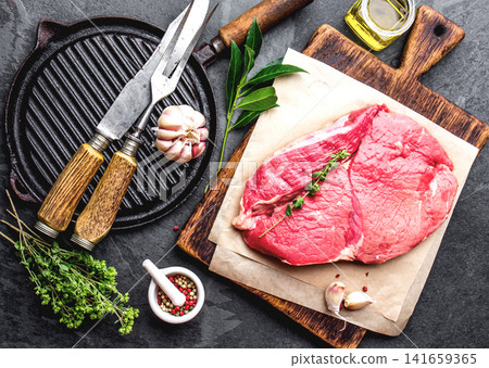 Raw Beef Steak on Wooden Cutting Board with Herbs and Spices Raw Beef Steak on Wooden Cutting Board with Herbs and Spices 141659365