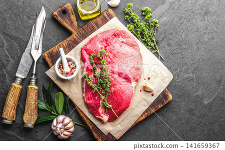 Raw Beef Steak on Wooden Cutting Board with Herbs and Spices Raw Beef Steak on Wooden Cutting Board with Herbs and Spices 141659367