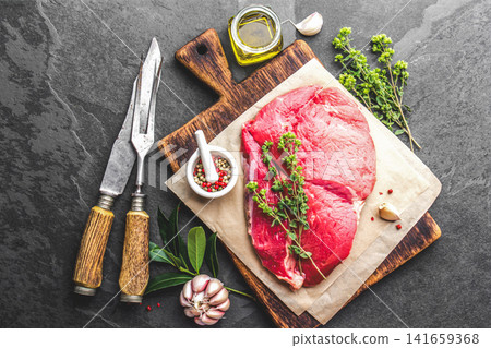Raw Beef Steak on Wooden Cutting Board with Herbs and Spices Raw Beef Steak on Wooden Cutting Board with Herbs and Spices 141659368