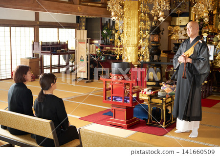 一位僧侶以金碧輝煌的內殿為背景,發表佈道,聽眾們全神貫注地聆聽。 一位僧侶以金碧輝煌的內殿為背景,發表佈道,聽眾們全神貫注地聆聽。 141660509