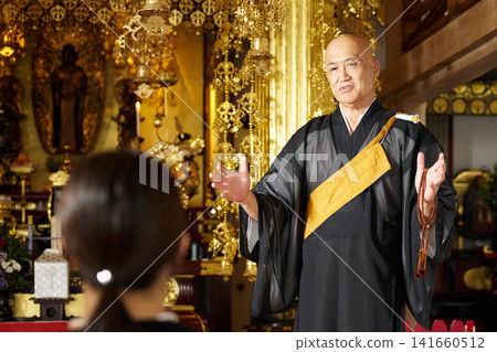 A Buddhist monk performing a memorial service in front of the altar in the main hall. 141660512