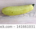 Whole pale green zucchini on light wooden table. Minimal composition. Selective focus Whole pale green zucchini on light wooden table. Minimal composition. Selective focus 141661031