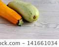 Yellow and pale green zucchini on white wooden table with copy space. Selective focus Yellow and pale green zucchini on white wooden table with copy space. Selective focus 141661034