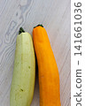 Yellow and pale green zucchini on light wooden table. Minimal food composition of fresh raw vegetables and contrasting colors. Yellow and pale green zucchini on light wooden table. Minimal food composition of fresh raw vegetables and contrasting colors. 141661036
