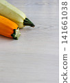 Yellow and pale green zucchini on white wooden table with copy space. Vertical food composition. Selective focus Yellow and pale green zucchini on white wooden table with copy space. Vertical food composition. Selective focus 141661038