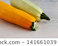 Yellow and pale green zucchini on white wooden table with copy space. Selective focus Yellow and pale green zucchini on white wooden table with copy space. Selective focus 141661039