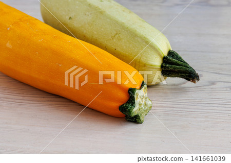 Yellow and pale green zucchini on white wooden table with copy space. Selective focus Yellow and pale green zucchini on white wooden table with copy space. Selective focus 141661039