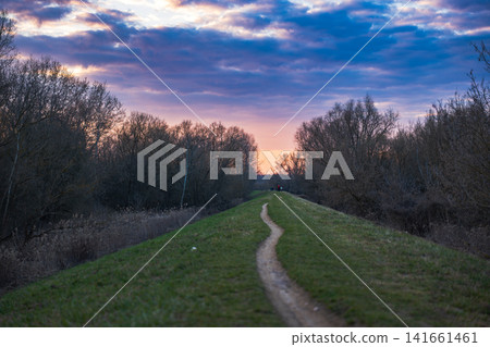 Grassy embankment path toward sunset near Vistula in Warsaw Grassy embankment path toward sunset near Vistula in Warsaw 141661461