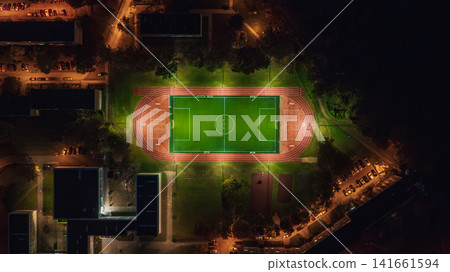 Aerial View of Illuminated Sports Field at Night in Urban Area 141661594