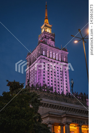 Palace of Culture and Science in Warsaw Lit with Purple and Yellow Lights 141661673