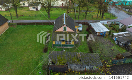 Aerial rural homestead in Belarus with repairs on mossy porch roof Aerial rural homestead in Belarus with repairs on mossy porch roof 141661742