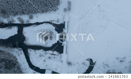 Aerial dam and sluice divide river and reservoir in Belarus winter 141661763