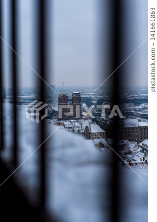 Snowy Wroclaw Old Town with twin tower church seen through bars Snowy Wroclaw Old Town with twin tower church seen through bars 141661863