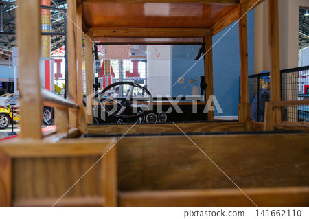 A view through the wooden cargo bed reveals the cab of a restored antique truck. The image captures historic vehicle design and construction. A view through the wooden cargo bed reveals the cab of a restored antique truck. The image captures historic vehicle design and construction. 141662110