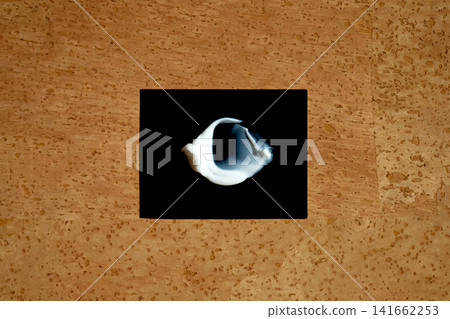 Cosmetics serum smear on black against cork background Cosmetics serum smear on black against cork background 141662253